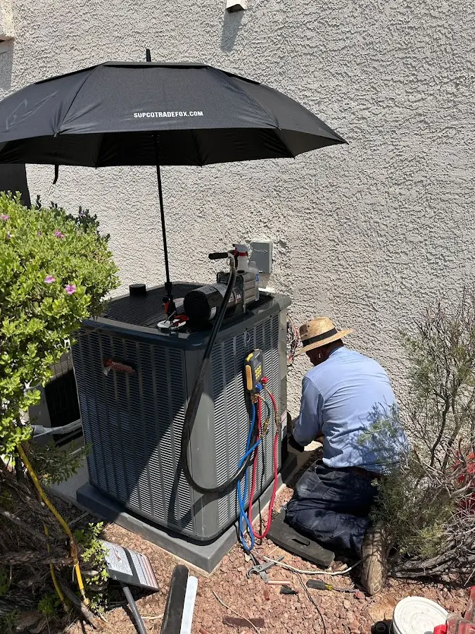 HVAC technician performing outdoor AC maintenance in Bakersfield